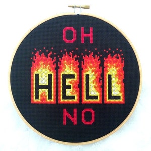 May include: Embroidered hoop art with the phrase "Oh Hell No" in red lettering. The word "Hell" is surrounded by pixelated flames in red, orange, and yellow.