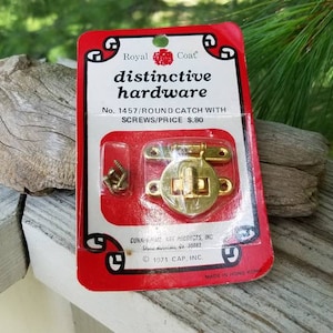 May include: A gold-colored round catch with screws, packaged on a red card with the text "Royal Coat distinctive hardware No. 1457/ROUND CATCH WITH SCREWS/PRICE $.80 CUNAHATE MFG. INC. 1971 CAP, INC."