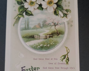 May include: Vintage Easter greeting card with a white floral design and a circular illustration of a country scene with a white picket fence and a path leading to a house. The text reads "God bless thee at this time of flowers, God bless thee through life's changing hours. Easter Greeting."