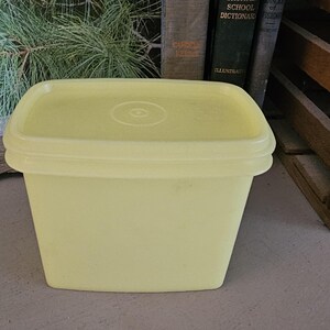 May include: A yellow plastic rectangular storage container with a lid. The container is empty.