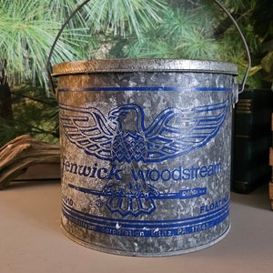 May include: A vintage galvanized metal bucket with a blue and white eagle logo and the text "Fenwick Woodstream Corporation Lititz, PA 17543 Floating".