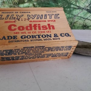 May include: A wooden box with a red and blue label that reads "Lily White Gloucester Style Codfish, Net Wt. 16 oz (One lb.) Slade Gorton & Co. Distributors: Boston, Mass. 02210".