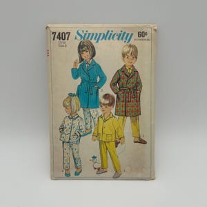 May include: Vintage Simplicity sewing pattern 7407 for child size 5. The cover features illustrations of children in pajamas and robes. The robes are teal and plaid, and the pajamas are floral and yellow. The price is 60¢.