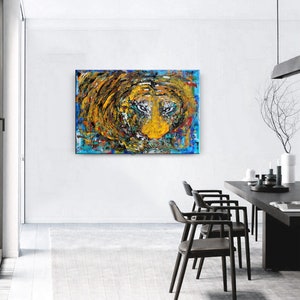 May include: Abstract painting of a lion's face in a swirling mix of yellow, blue, green, and red paint. The lion's eyes are prominent and intense.
