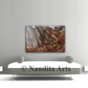 Abstract painting of a guitar with red, orange, and brown paint. The guitar is in the center of the painting and is surrounded by abstract shapes and lines. The painting is on a white wall and is framed in a black frame. The painting is titled 'Guitar' and is signed by the artist 'Nandita Arts'.