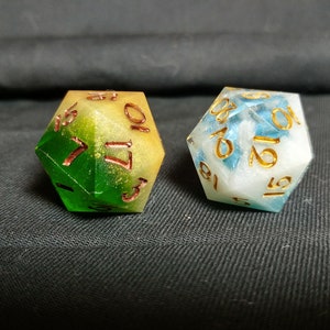 Pu&ograve; includere: Due dadi multicolori con numeri dorati. Un dado &egrave; verde, giallo e bianco con numeri dorati. L'altro dado &egrave; blu, bianco e oro con numeri dorati.