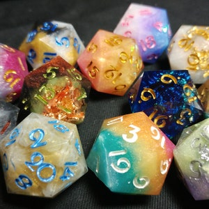 May include: A set of ten iridescent dice with gold and white numbers. The dice are made of resin and have a variety of colors, including pink, blue, green, and orange.
