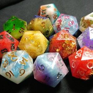 Pu&ograve; includere: Un set di dieci dadi multicolori con glitter dorati e argentati incorporati nella resina. I dadi sono numerati da 1 a 6 e presentano una variet&agrave; di colori, tra cui rosso, verde, blu, viola e giallo.