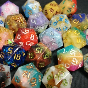 Pu&ograve; includere: Una collezione di dadi a 20 facce con vari colori e glitter incorporati nella resina. I dadi sono numerati da 1 a 20 con lettere dorate.