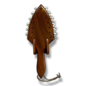 May include: A wooden Hawaiian weapon called a "kapa" with a brown wooden handle and a blade decorated with white shark teeth.