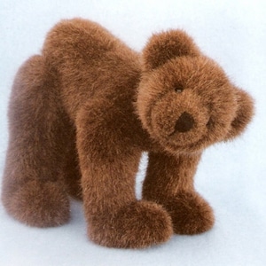 Può includere: Un orsacchiotto di peluche marrone in piedi. L'orso ha una texture pelosa e un'espressione amichevole.