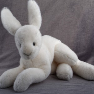 May include: A white plush bunny rabbit toy with long ears and a soft, fluffy texture.
