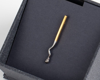 Spilla a forma di fiammifero dorato bruciato, in argento sterling placcato oro 24 carati. Abbinamento perfetto.