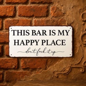 May include: A rectangular white metal sign with a dark brown border and four corner holes. The text reads THIS BAR IS MY HAPPY PLACE in bold black capital letters, followed by the cursive script text don't f*ck it up in black.
