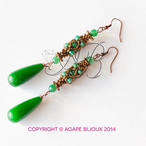 May include: A pair of long, green and gold earrings with teardrop-shaped green stones. The earrings are made with small beads and wire.