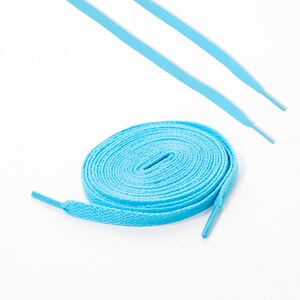 May include: A pair of light blue shoelaces, one is coiled up and the other is laid out straight.