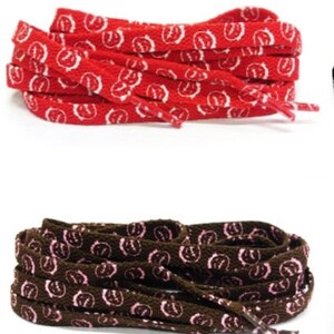 Puede incluir: Dos pares de cordones. Un par es rojo con un patr&oacute;n blanco, y el otro es marr&oacute;n con un patr&oacute;n rosa. Los cordones est&aacute;n hechos de un material tejido y son adecuados para zapatillas deportivas u otros tipos de zapatos.