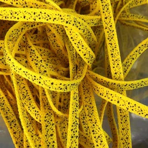 Our custom yellow speckled or yellow cement laces are perfectly paired with the Nike Jordan 4 Yellow Thunder or Jordan 4 Lightning. The speckle or cement print as sneaker enthusiasts like to call it, are an homage to the retro colorways and prints of the original Nike Jordan sneakers that were created in the 1990s. This is a detailed up close look of the yellow laces with black speckle print.