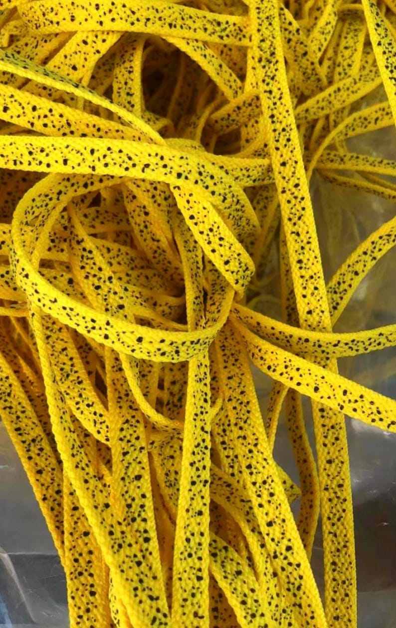Our custom yellow speckled or yellow cement laces are perfectly paired with the Nike Jordan 4 Yellow Thunder or Jordan 4 Lightning. The speckle or cement print as sneaker enthusiasts like to call it, are an homage to the retro colorways and prints of the original Nike Jordan sneakers that were created in the 1990s. This is a detailed up close look of the yellow laces with black speckle print.