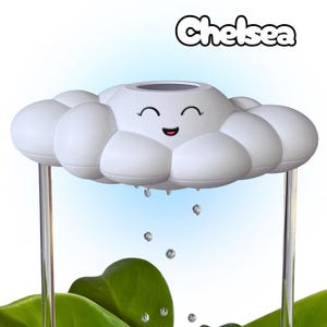 May include: A white cloud-shaped humidifier with a smiling face and the name "Chelsea" above it. Clear tubes support the cloud, with water droplets falling onto green leaves below. The background is a gradient of blue and white.
