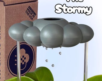May include: A gray cloud-shaped plant watering device labeled The Stormy, featuring a central opening and clear support rods. The device is positioned above green leaves, with water droplets falling from the cloud base into the plant foliage below.