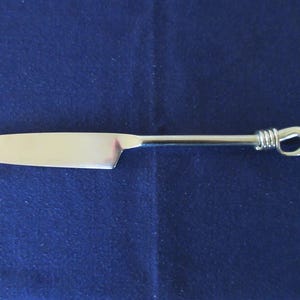 May include: A silver butter knife with a twisted handle.