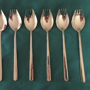 May include: Six silver salad forks with a polished finish. The forks have a rounded bowl and four tines.