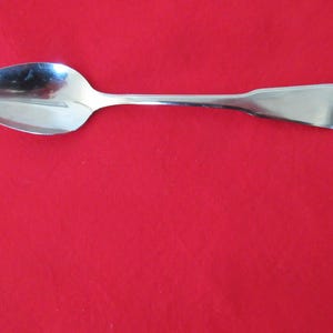 Peut inclure: Une cuillère en argent avec un bord dentelé et un bol arrondi. La cuillère est conçue pour prélever les fruits.