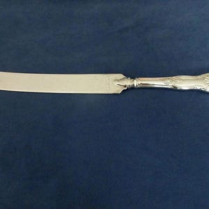 Ornate SHEFFIELD Wedding Cake KNIFE ? with 8" Embossed Blade in KINGS Pattern w/Raised Shell Crown on Handle marked Sheffield Good Condition