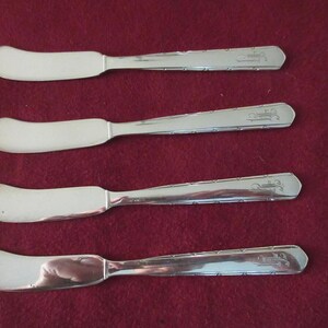 4 cuchillos/untadores de mantequilla Ind Silverplate con mango plano de GORHAM en el patrón REMBRANCE. Mangos rectos con líneas punteadas en los laterales con monograma. ¡Buen estado!