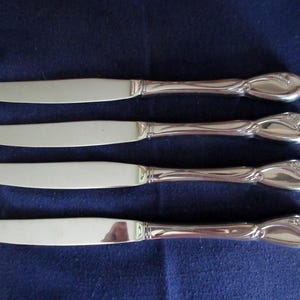 4 Vtg Glossy Stainless Dinner KNIVES from Oneida Deluxe 18/8 Flatware CALLA LILY Pattern  Flower Embossed on Handle Lightly Used Condition!