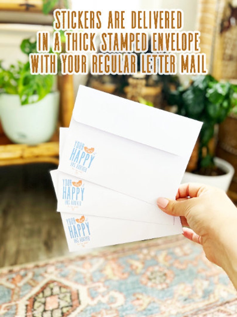 K&ouml;nnte beinhalten: Drei wei&szlig;e Umschl&auml;ge mit einem blauen und orangefarbenen Logo, auf dem "Your Happy Has Arrived" steht. Die Umschl&auml;ge sind &uuml;bereinander gestapelt und werden von einer Hand gehalten. Der Text "Stickers are delivered in a thick stamped envelope with your regular letter mail" ist im Hintergrund sichtbar.