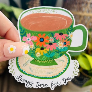 May include: A green teacup with a floral design and the text "always time for tea" on a white background.