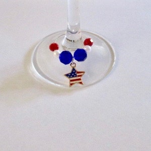 Puede incluir: Un charm para copa de vino con cuentas rojas, blancas y azules y un charm en forma de estrella con un diseño de bandera estadounidense.