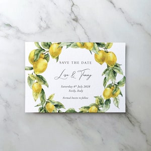 May include: Save the date card featuring a watercolour illustration of a lemon tree branch with yellow lemons and green leaves. The text reads "Save the Date, Lisa & Tommy, Saturday 6th July 2028, Sicily, Italy, Formal Invite to follow."
