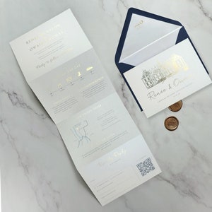 May include: A wedding invitation suite featuring a tri-fold card with gold foil text and a map, alongside a rectangular card with a gold foil illustration of a chateau, a navy blue envelope with gold monogram, and two round bronze wax seals.