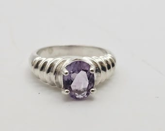 May include: A silver ring with a twisted band and a purple amethyst gemstone.