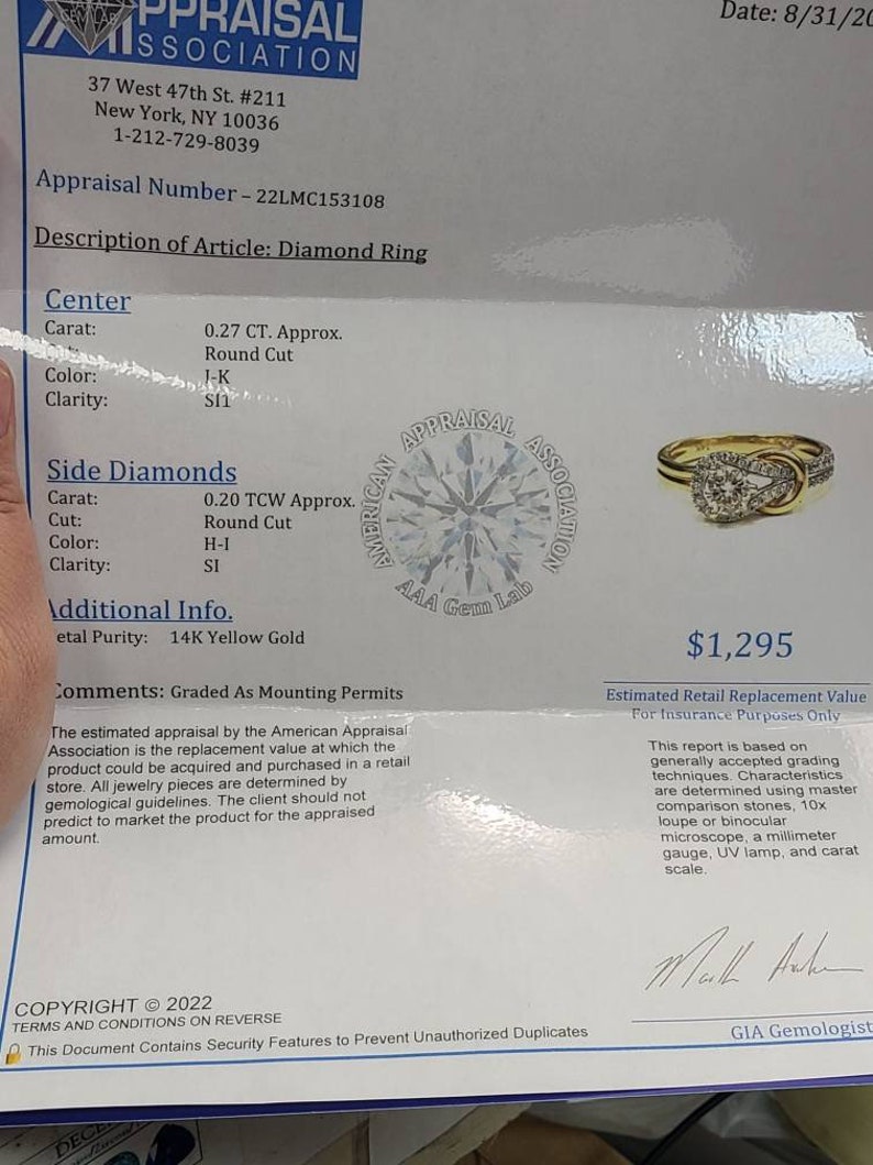 May include: An appraisal document for a diamond ring. The document includes details such as the carat weight, cut, color, and clarity of the center and side diamonds. The ring is 14K yellow gold. The estimated retail replacement value is $1,295.