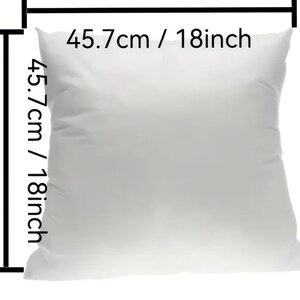 May include: A square, white pillow, 18 inches (45.7 cm) in length and width. The pillow is plain and appears to be made of a soft fabric. The dimensions are clearly labeled on the image.