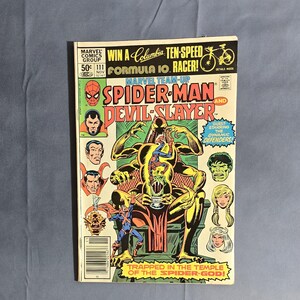 May include: A comic book cover featuring Spider-Man and Devil-Slayer. The cover is yellow, red, and green with a large image of a monstrous creature with Spider-Man fighting it. The text on the cover reads "Marvel Team-Up Spider-Man and Devil-Slayer".