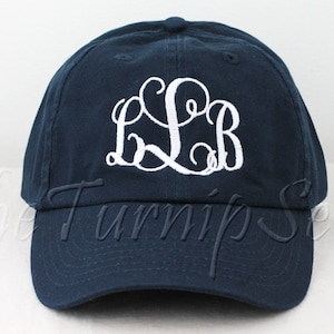May include: A navy blue baseball cap with a white embroidered monogram "L.S.B."
