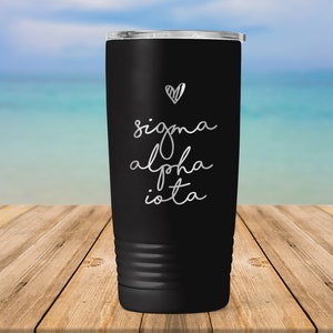 May include: Black stainless steel tumbler with a silver heart and the text "sigma alpha iota" in a handwritten font.