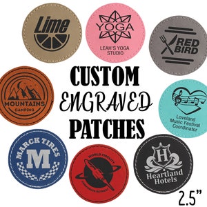 May include: Assortment of 2.5 inch round custom engraved patches in various colors and designs.  The patches feature text such as "Lime", "Yoga", "Mountains Camping", "Red Bird", "Loveland Music Festival Coordinator", "World Fidelity Corporate Retreat", "Heartland Hotels", and "Marc Tires".