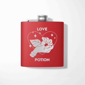 May include: Red metal flask with a silver lid and a design of a hand holding a rose inside a heart with the words "LOVE POTION" printed on it.
