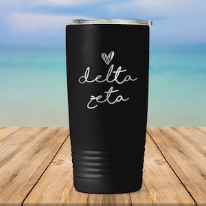 May include: Black stainless steel tumbler with a silver heart and the text "delta zeta" on the front.