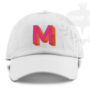 May include: White baseball cap with a pink and orange embroidered letter M.