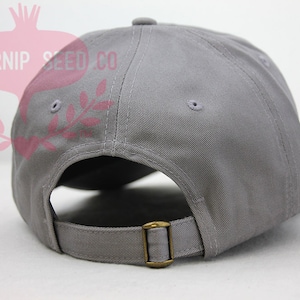 May include: A gray baseball cap with a brown adjustable strap in the back.
