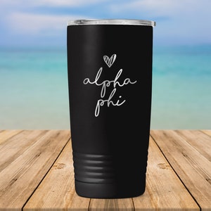 May include: Black stainless steel tumbler with a white heart and the text "alpha phi" on the side.