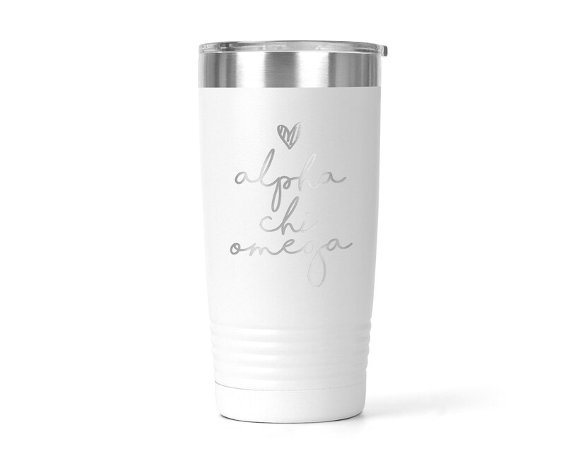 K&ouml;nnte beinhalten: Ein wei&szlig;er Edelstahlbecher mit einer silbernen Aufschrift, die "alpha chi omega" lautet, mit einem kleinen Herzen &uuml;ber dem Text.