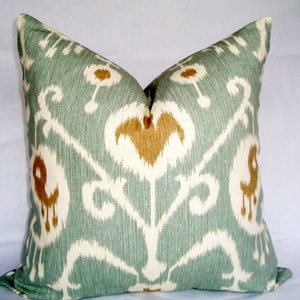 May include: A decorative throw pillow with a teal, white and brown ikat pattern.